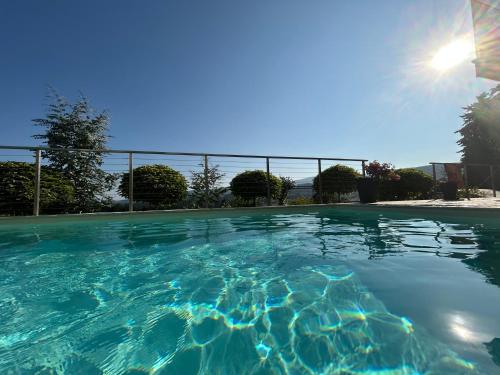 a large swimming pool with the sun in the background at Traumhaus in den Weinbergen - max 8 Personen - mit Self-Check-in in Sankt Stefan ob Stainz