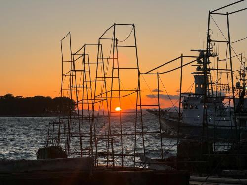 a boat sitting in the water at sunset at TAKUMI-AN Private Ancient House and Garden in Numazu