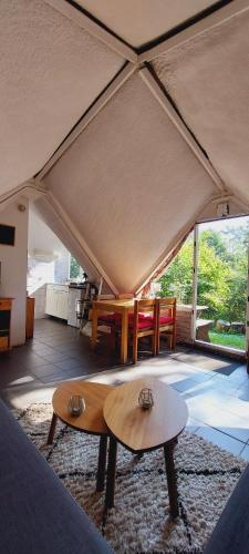 a room with two tables and chairs in a tent at Charmant petit chalet dans la forêt in Gesves