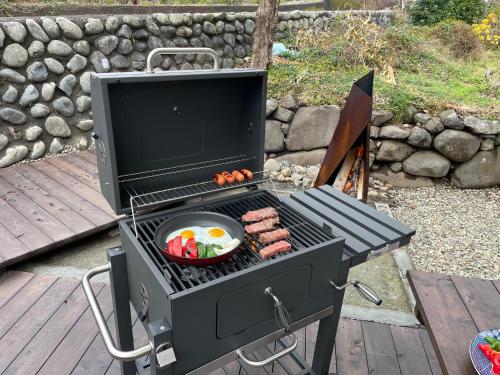 a grill with a bowl of hot dogs and vegetables at TAKUMI-AN Private Ancient House and Garden in Numazu