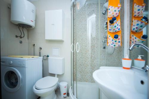 een badkamer met een toilet, een wastafel en een wasmachine bij Apartment Nina in Split