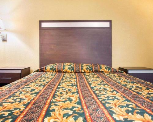 a bed in a hotel room with a colorful bedspread at Rodeway Inn Mount Laurel Hwy 73 in Mount Laurel