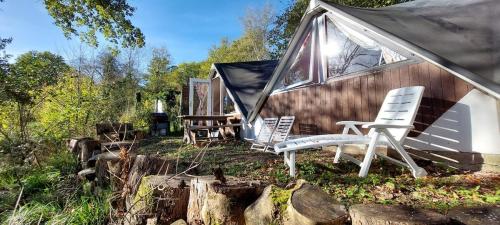 a group of chairs sitting outside of a tent at Charmant petit chalet dans la forêt in Gesves