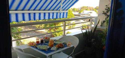 a tray of food on a table on a balcony at Charmant studio avec parking et terrasse à Papeete in Papeete