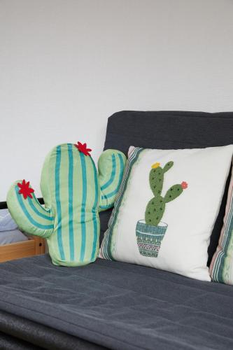 a bed with a pillow with a cactus on it at Sweet House東池袋 in Tokyo