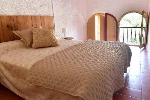 a bedroom with a large bed with a white comforter at La Caseta del Priorat III in Porrera