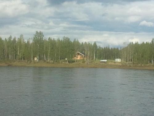 a house sitting on the shore of a lake at Savutaival in Pello