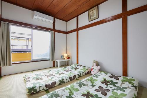 a bedroom with two beds and a large window at Sweet House東池袋 in Tokyo