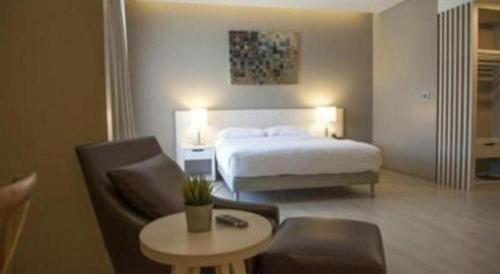 a hotel room with a bed and a table and chairs at Double G Resort Anyer in Carita