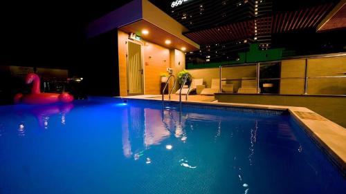 a large swimming pool with blue lights in a building at Bel-air Hotel in Quy Nhon