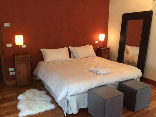 a bedroom with a large white bed with two lamps at Tre Alberi Liberi in Alagna Valsesia