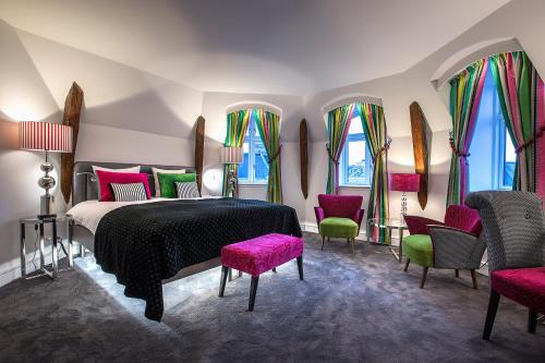 a bedroom with a bed and chairs and windows at Absalon Hotel in Copenhagen
