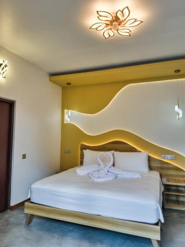 a bedroom with a white bed with a butterfly on it at Thundi Villa in Maalhos