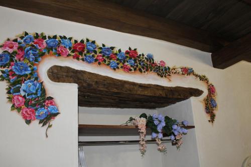 a decorated arch with flowers on a wall at Vesta in Sorgono