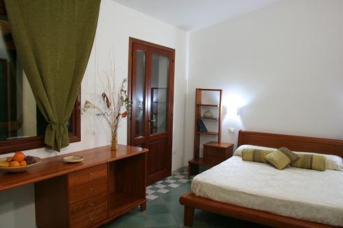 a bedroom with a bed and a bowl of fruit on a table at Guardia dei Mori in Carloforte