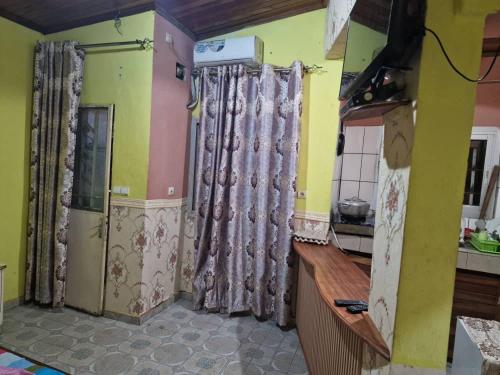 a kitchen with curtains on the wall and a counter at Complexe la samaritaine in Yaoundé