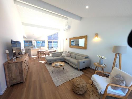 a living room with a couch and a table at Villa Salina - 150m to One Mile Beach in Forster