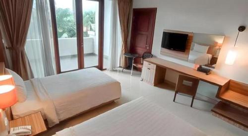 a large hotel room with a bed and a television at The Oxalis Regency Hotel in Magelang