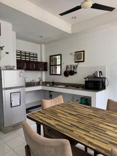 a kitchen with a wooden table with chairs and a refrigerator at 103/24 Kathu Waterfall in Phuket Town