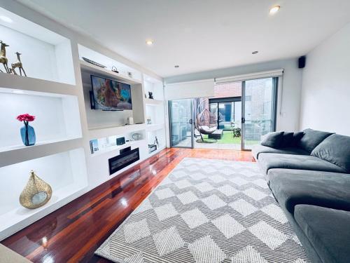 a living room with a couch and a fireplace at Luxe Riverside Oasis 3BR for 6 Guests Home Near Flemington Racecourse 16 min to CBD 20 min to Airport 2 mins walk to Public Transport to go to Train Station and Highpoint Shopping Centre in Melbourne