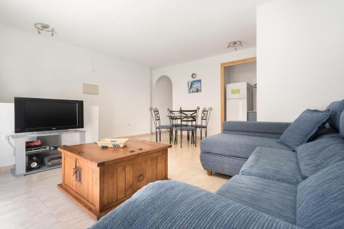 uma sala de estar com dois sofás azuis e uma mesa em Apartamento Castillejos em Tarifa
