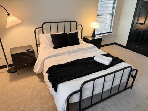 a bedroom with a black and white bed and a window at Bishop Hostel in Dallas