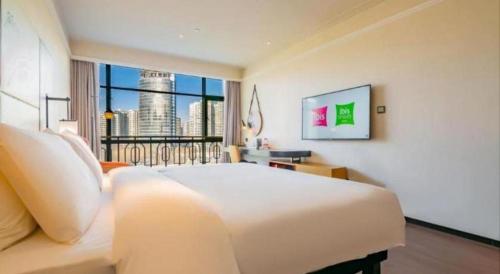 a bedroom with a large white bed and a large window at ibis xian North Second Ring Weiyang Rd Hotel in Xi'an