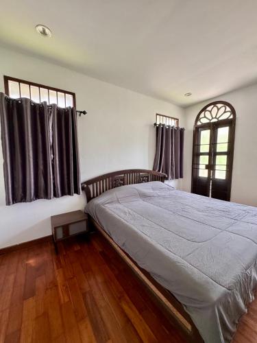 a bedroom with a large bed and a window at 103/24 Kathu Waterfall in Phuket