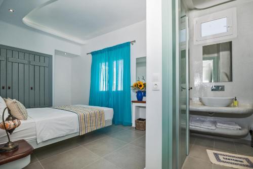 um quarto com uma cama e um lavatório em Petini's Place em Fira