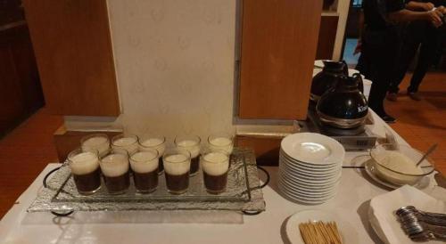a tray of cupcakes on a table with plates at Alexander Hotel Tegal in Tegal