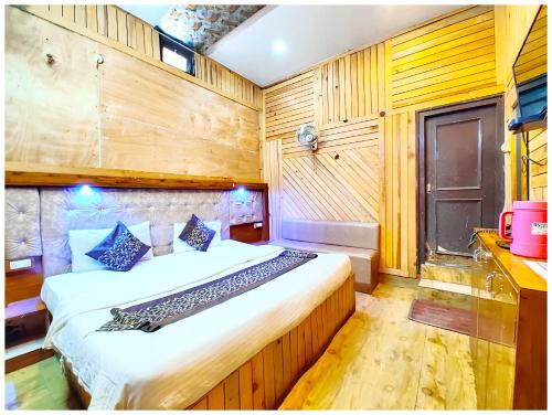 a bedroom with a bed in a room with wooden walls at Hotel Lake Naini View - Restaurant &Free Wifi Available - Luxury Collection of Hotels with Spacious Room - Best Lake View Hotel In Nainital in Nainital