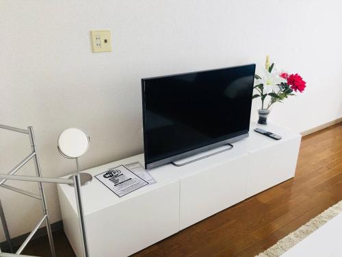 a flat screen tv sitting on top of a white cabinet at Apartment in Narita 110 in Narita