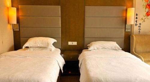two beds in a hotel room with white sheets at Jiaxin Conifer Hotel Shunde in Shunde