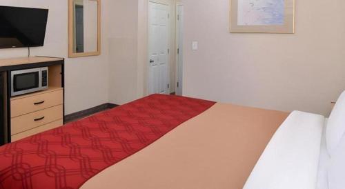 a bedroom with a bed with a red blanket at Econo Lodge Rochester I-90 & I-390 in Rochester