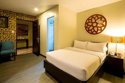 a bedroom with a bed and a room with a chair at L Square Hotel in Tarlac