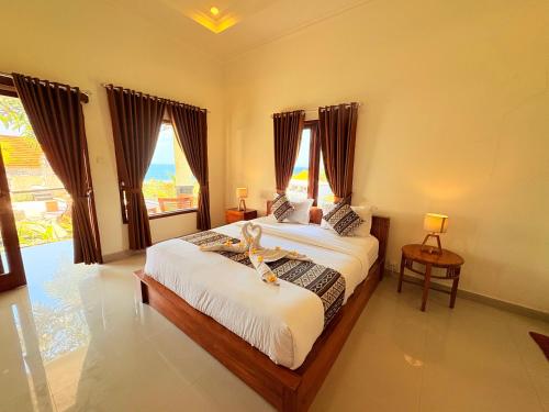 une chambre avec deux lits et une grande fenêtre dans l'établissement Pooja Ocean View Cottage, à Nusa Penida