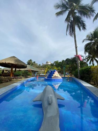a pool at a resort with a dolphin in the water at Libhu Hill Resort and Sports Complex in Maasin