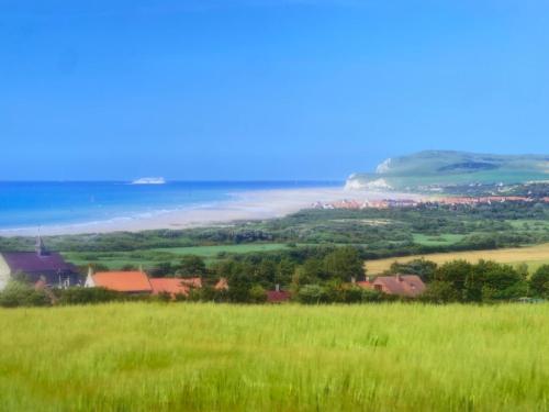 a green field with the ocean in the background at Wissant Villa Colombine in Wissant