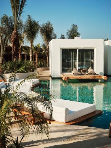 a swimming pool with a white house with a swimming pool at Aya Resort - Adults Only in Ayia Napa