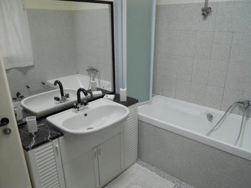 een badkamer met een wastafel, een bad, een wastafel en een spiegel bij Cà Mea in Imperia