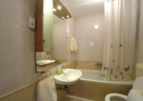a bathroom with a sink and a toilet and a tub at Apartment Pizzybondo in Split