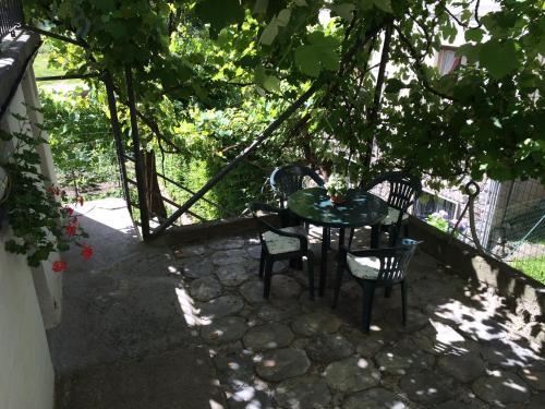 a patio with a table and chairs under a tree at Bed & Breakfast Casa Marinella in Lenna