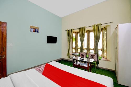 a room with a bed and a table with a red blanket at Hotel O Monalisa Guest House in Bhubaneshwar