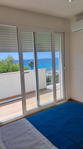 a room with large windows and a blue carpet at maraneri rooms in Bovalino Marina