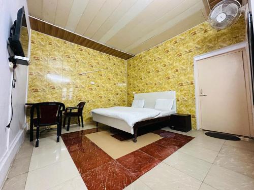 a bedroom with a bed and a table and chairs at Aagman Homestay & Rooftop Restaurant in Mussoorie
