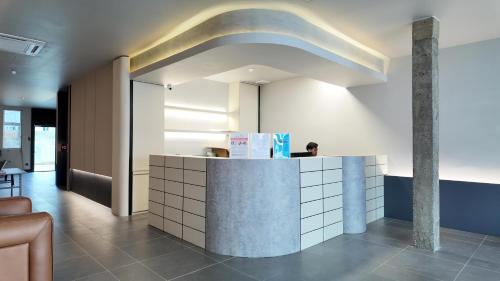 a person sitting at a counter in a lobby at Urban Inn, Cengal Jaya in Sungai Petani