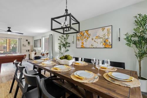a dining room with a wooden table and chairs at Summer Splash Pool, Spa & Game Room in Mesa