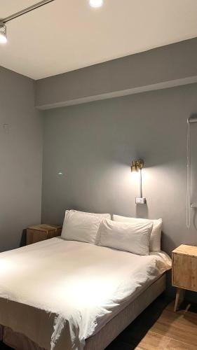 a bedroom with a large bed with white sheets at Taitung Sun forest in Taitung City
