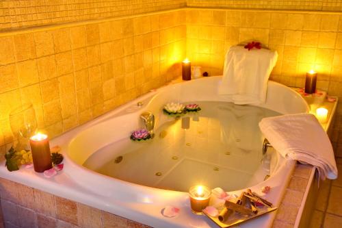 a bathroom with a bath tub with candles in it at Garden Playanatural - Adults Only in El Rompido
