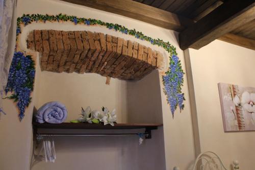 a room with a shelf with flowers on the wall at Vesta in Sorgono